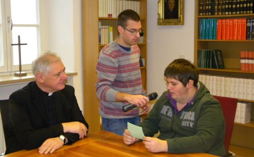 Zu Gast bei dem damaligen Regensburger Bischof, Dr. Gerhard Ludwig Müller: Pierre Ziebarth (rechts) stellt seine Fragen, u. a.: „Wer kümmert sich eigentlich um Sie?“ Ulrich Macht bedient das Mikrophon. (Quelle: Carl Prämaßing)