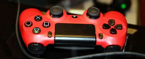 roter Computerspiele-Controller mit schwarzen Knöpfen