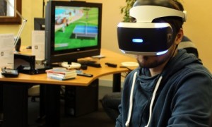 Mann mit VR-Brille vor Computerspiel