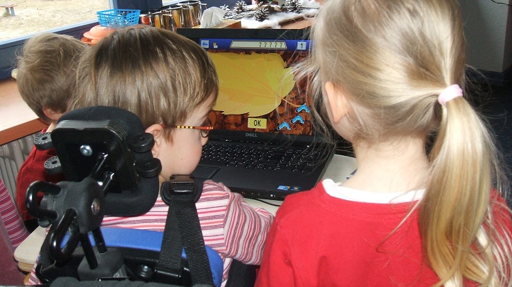 Kind im Rollstuhl vor Computerspiel