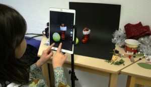 Mädchen fotografiert mit Tablet Weihnachtsmotive vor schwarzem Hintergrund