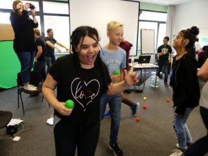 Mädchen und Jungen des inklusiven Mediencamps laufen mit bunten Bällen in der Hand durcheinander