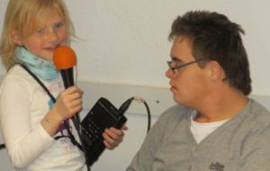 Mädchen mit Mikrofon und Aufnahmegerät und Junge
