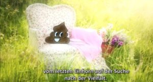 Filmausschnitt: Eine Blumenwiese mit einem alten Sessel mit geblümten Stoffbezug. Darauf Kacki, der Erzähler - Kothaufen mit Smiley-Gesicht. Untertitel: "vom letzten Einhorn auf der Suche nach Vielfalt"
