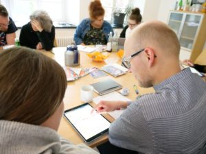 Weiterbildungsteilnehmende arbeiten konzentriert am Tisch mit Laptops