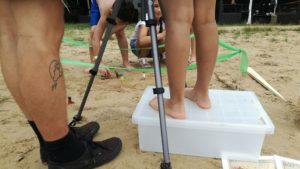 Beim Trickfilmen am Strand: Ein Mädchen steht auf einer Kiste und filmt mit dem iPad