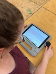 Eine Jugendliche nimmt eine Sprachaufnahme am iPad auf