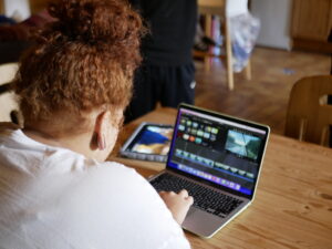 Person am Laptop schneidet ein Video am Laptop