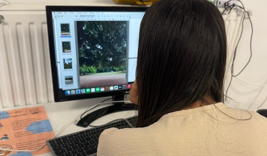 Ein Mädchen sitzt vor einem Computer und bearbeitet ihr Foto.